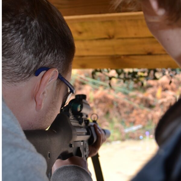 Close Up of a man .22 Assault Rifle Shooting standing next to an instructor
