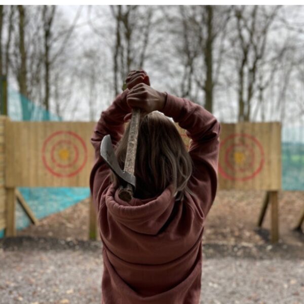 A girl holding an Axe behind her head ready to Throw at targets