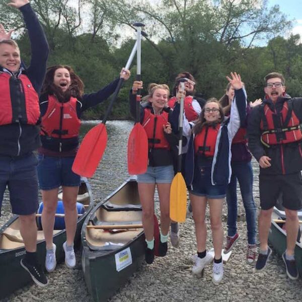 A group jumping in the air before their Canoeing Gift Experience day