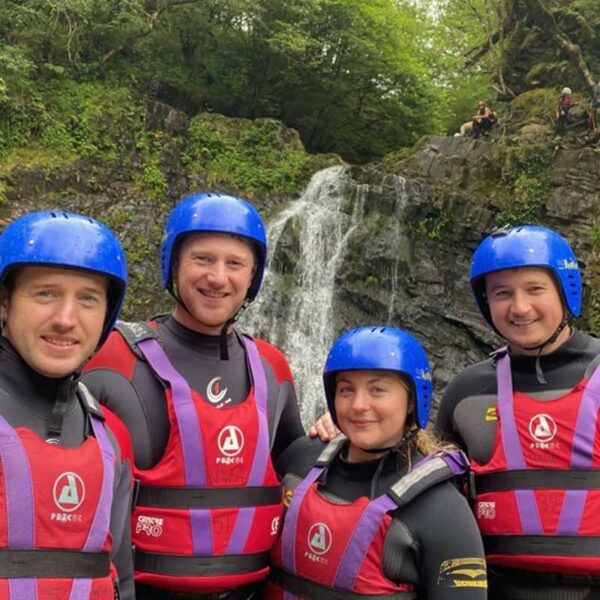 4 people posing in front of a waterfall during their Canyoning Gift Experience Day