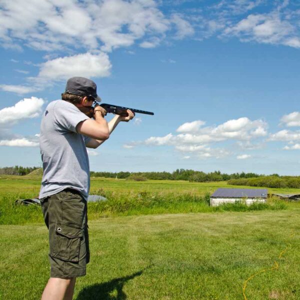 A man aiming down the barrel of a gun ready to shoot a Clay Pigeon