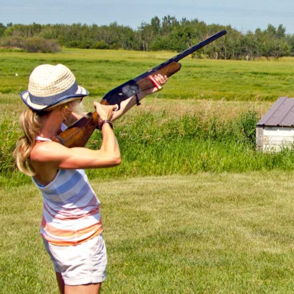 A woman aiming her gun in the air ready to shoot a Clay Pigeon