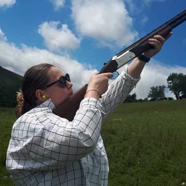 A woman aiming her gun towards the sky for Clay Pigeon Shooting