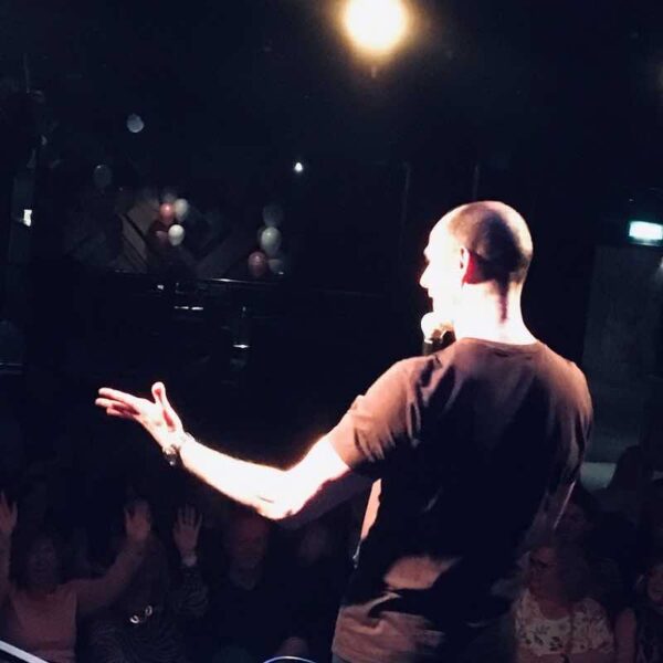 Comedian speaking to a crowd at a Comedy Club