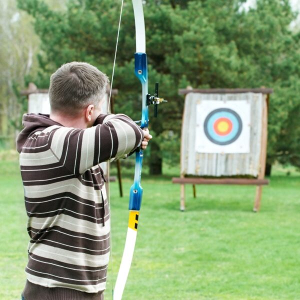 An archer drawing his bow back ready to fire into a target for a Designa Combo activity day