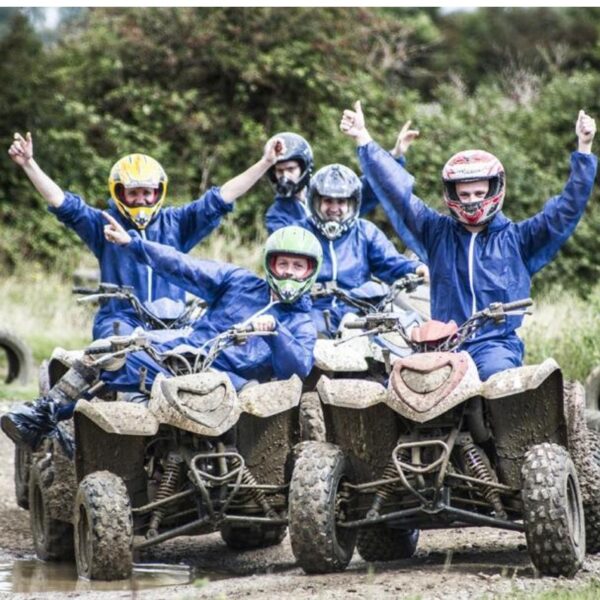 A group dressed in helmets and blue overalls on Quad Bikes during a Designa Combo activity day