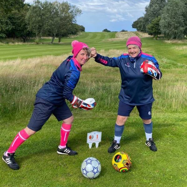 2 ladies wearing Football socks and boots, battling it out over Footgolf 18 Holes