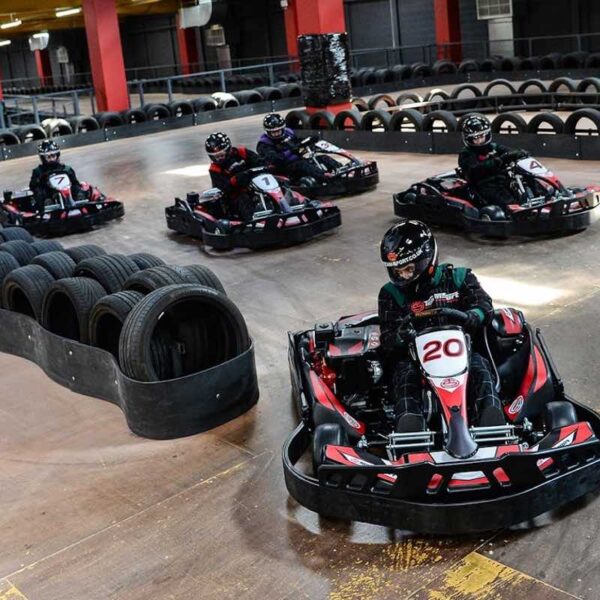 A group racing round the track on an Indoor Karting Open Team Ultimate Race Gift Experience Day