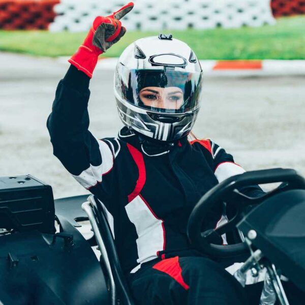 A woman dressed in overalls and a helmet Indoor Karting on an Open Team Ultimate Race