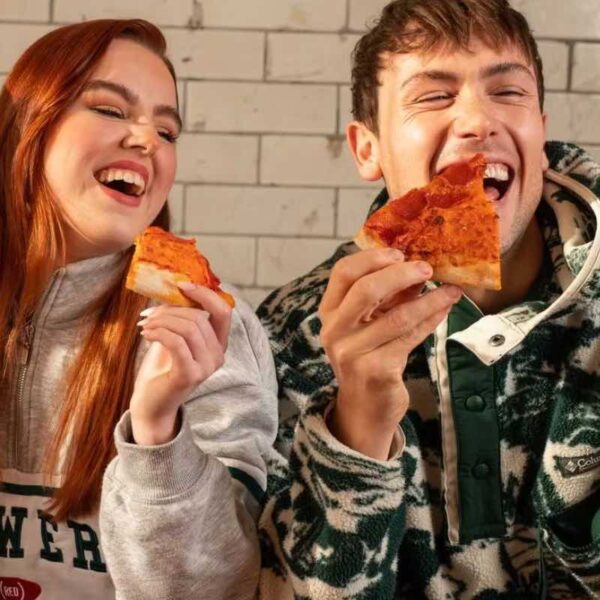 Two people laughing holding Pizza slices in Revolution