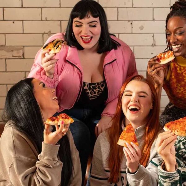 Four friends in Revolution laughing holding Pizza