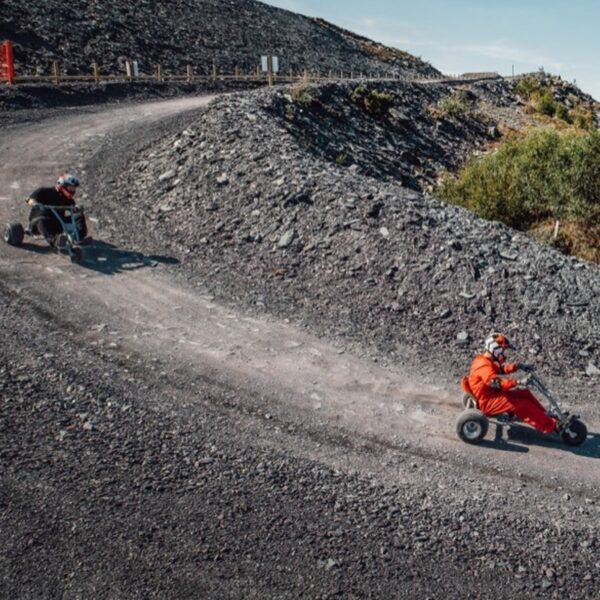 Two people in Quarry Karts zooming down the hill