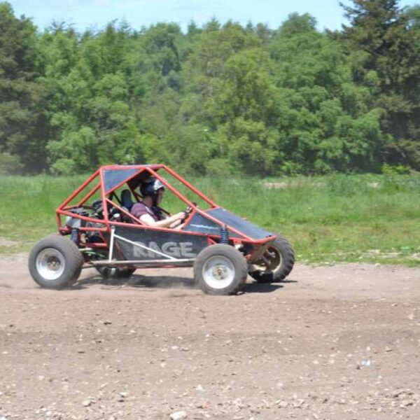 Rage Buggies racing around a dirt track on a sunny day