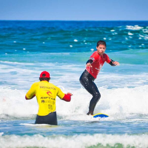Instructor in ocean teaching a student Surfing