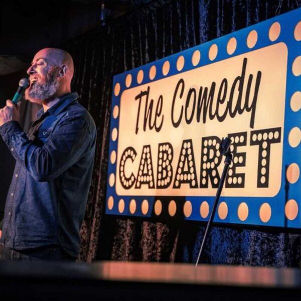 A stand up comedian speaking to a crowd at The Comedy Cabaret