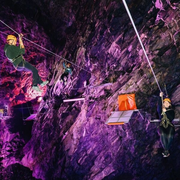 Two people Zip Lining in the Zip Wire Caverns
