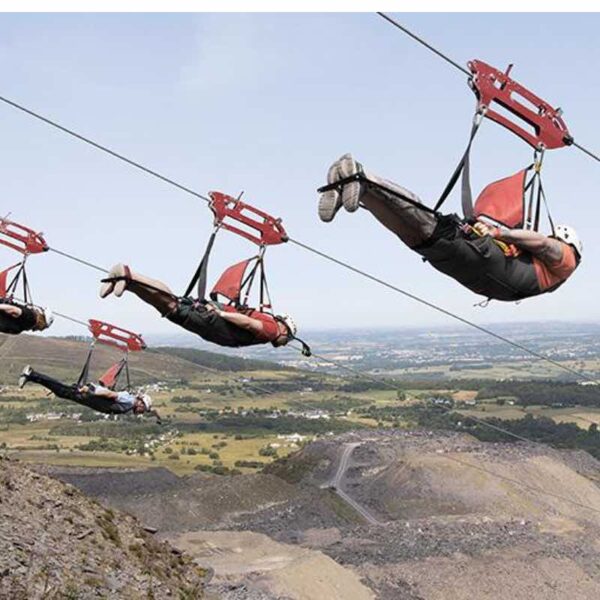 A group zipping down the Zip Wire Velocity superman style wearing helmets