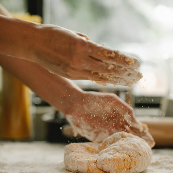 A close up of someone's hands kneading dough in a Baking Masterclass