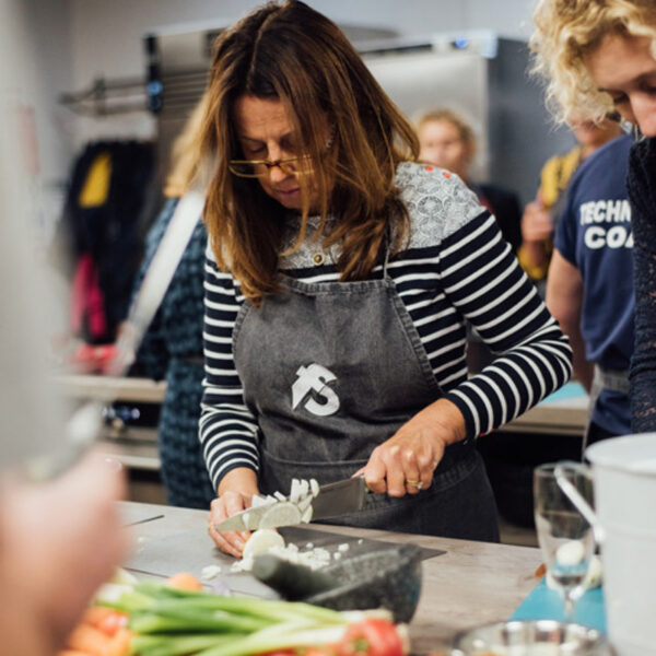 A woman dicing an onion in a Cookery Masterclass