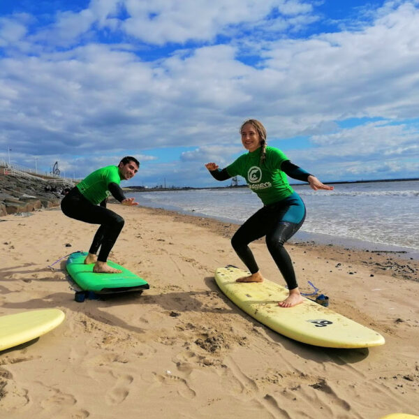 2 people learning to surf in Swansea